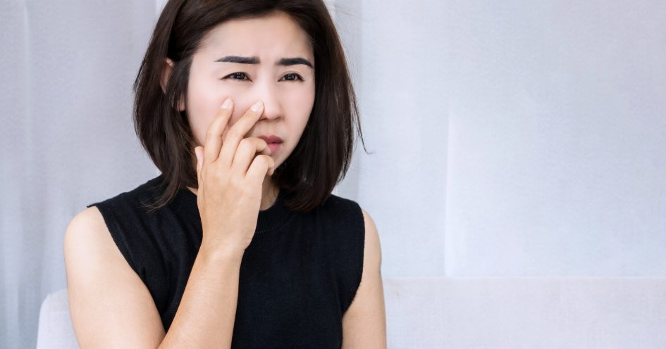 Woman touching the side of her nose, where one nasal passage feels blocked